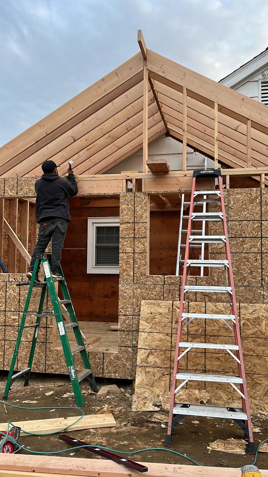 Wood framing and roofline taking shape on a home addition